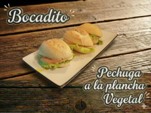 Tres bocaditos de pan con lechuga y pechuga a la plancha vegetal sobre un plato.