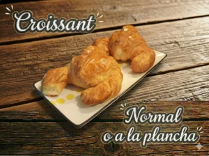 Croissants dorados sobre un plato blanco, con texto decorativo en la parte superior.