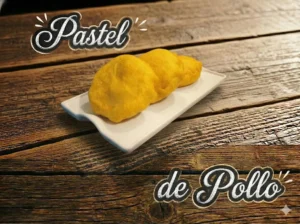 Tres pasteles de pollo amarillos en un plato sobre una mesa de madera.
