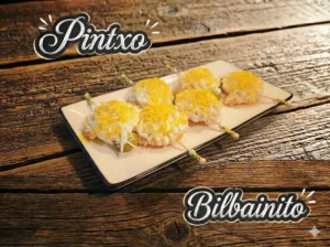 Plato con cinco pintxos bilbainitos, decorados con mayonesa y huevo rallado.
