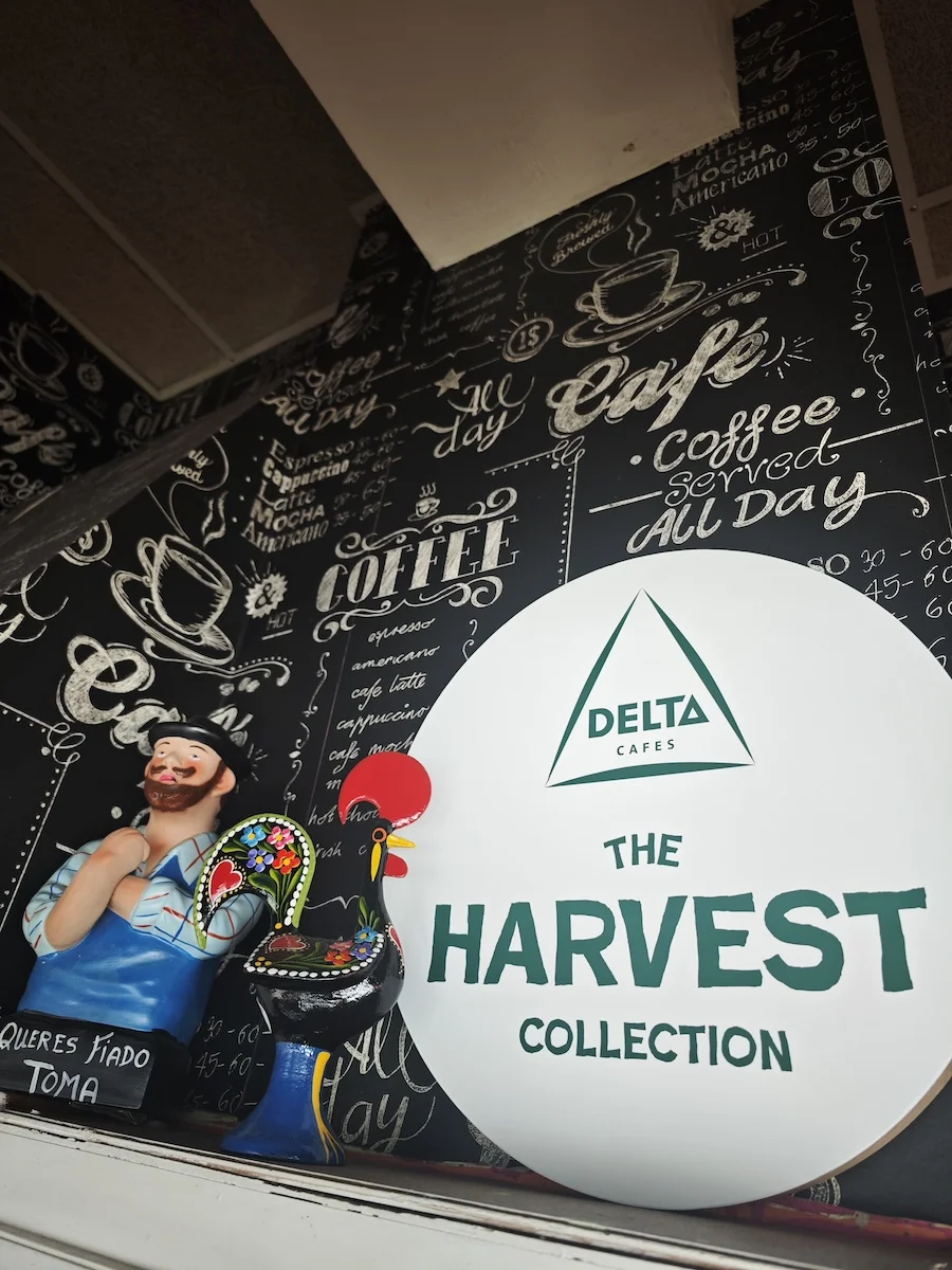 Decoración de café con un mural negro, un muñeco y un cartel de "The Harvest Collection".