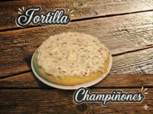 Tortilla con champiñones sobre un plato blanco, sobre una mesa de madera.